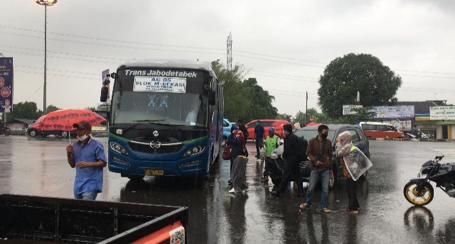 Terabas Hujan Deras untuk Naik Bus Kota di Gerbang Tol Bekasi Timur