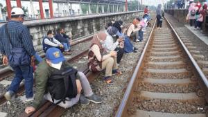 Tunggu KRL, Calon Penumpang Berderet Duduk di Rel Stasiun Tambun Jumat Pagi